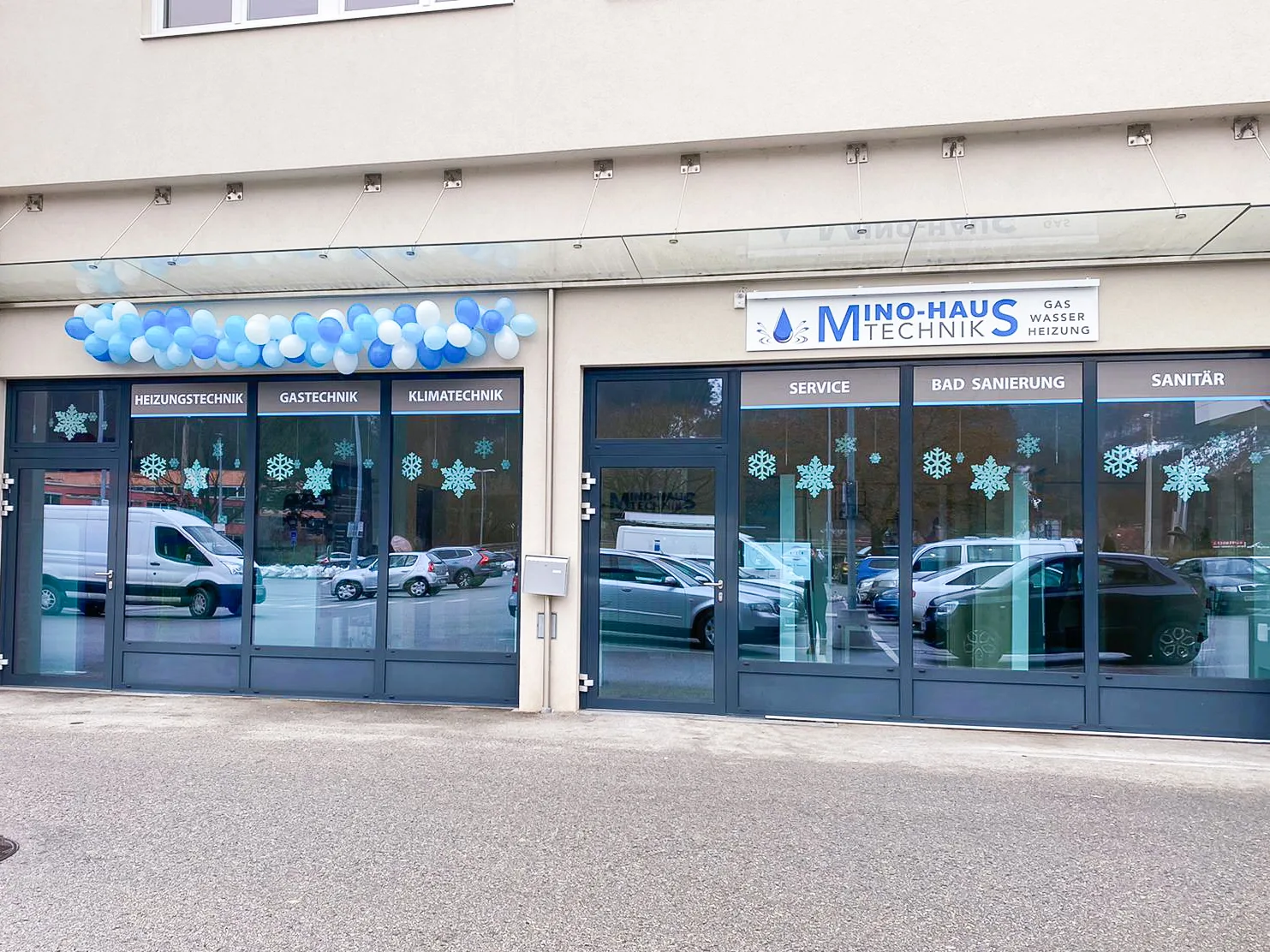 Geschäftsfront von Mino-Haustechnik mit Firmenschild und den Schaufensterwörtern Heizungstechnik, Gastechnik, Klimatechnik, Service, Bad Sanierung und Sanitär